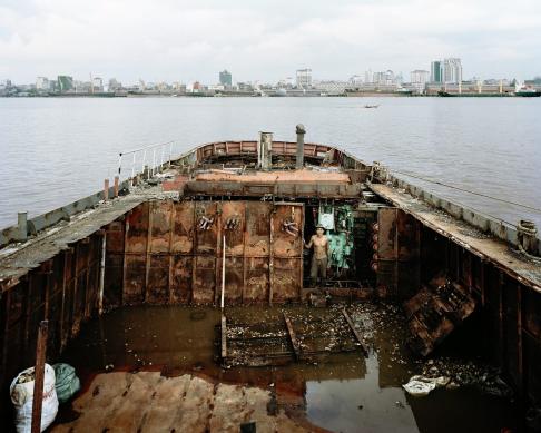 A worker on an Indian-owned vessel pauses for a portrait. This ship has been hauled on-shore in Dala Township across from the downtown Yangon on the Yangon River for repairs before setting out again for sea.