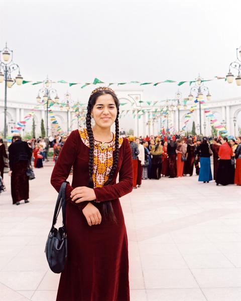 A young woman in her Turkmen finery stops for a photo at 'A Drop of Water is  Grain of Gold Day' celebration in Independence Park in Ashgabat, Turkmenistan.