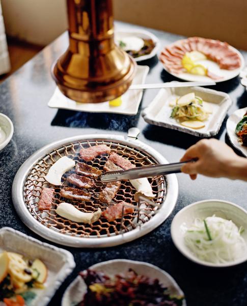 Park Daegamne BBQ Restaurant in Seoul, South Korea. Pictured here is meat on the barbecue grill along with several side dishes including:

 1. Yeongeun Kae sauce muchim - seasoned lotus root with sesame sauce 
 2. MyeongEeNaMul - Seasoned allium moly(herb) from Ulleung Island
 3. Sangchugeotjeolee - Seasoned lettuce
 4. Soondoobu - Soft Tofu
 5. Osaekjobab -  five colours of seasoned rice
